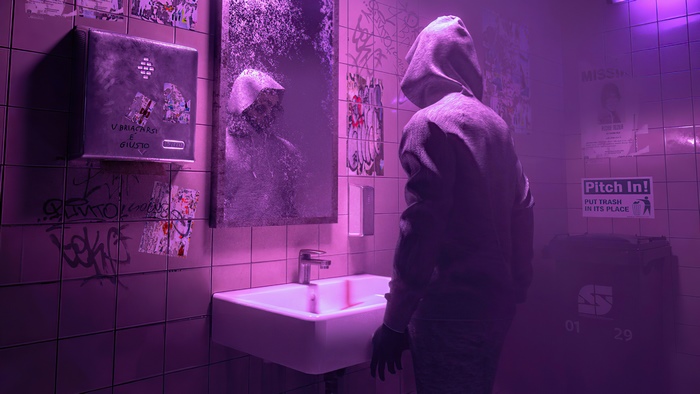 Hooded figure in a graffiti-covered bathroom