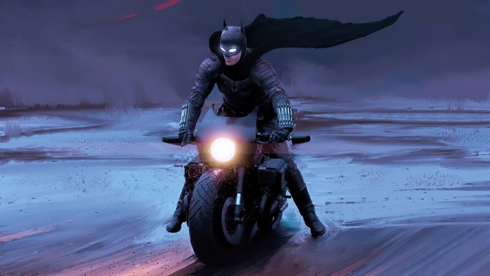 Batman on a motorcycle in a dark landscape