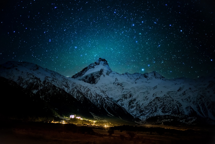Snowy mountains under a starry night sky