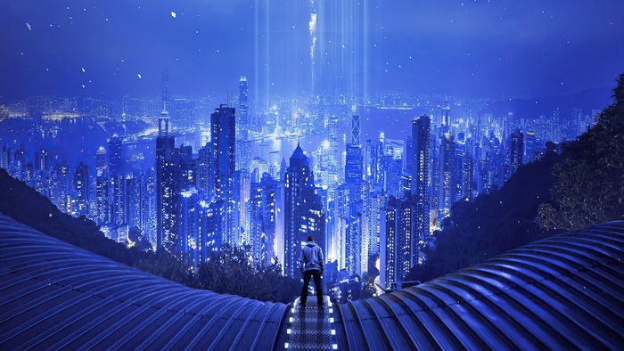 Man in hoodie overlooking futuristic city at night