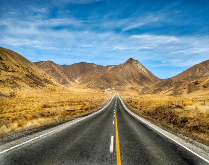 Road through mountains under blue sky