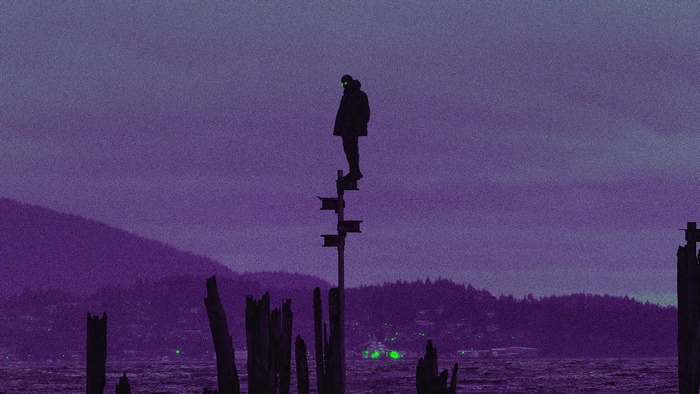 Silhouette of a person standing on metal beams over water