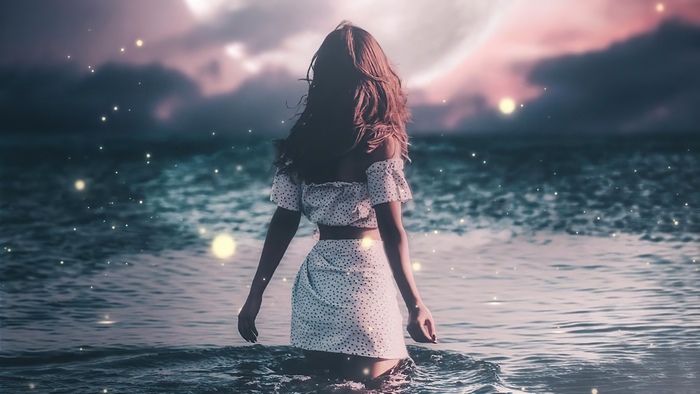 Woman in polka dot dress in the ocean at night