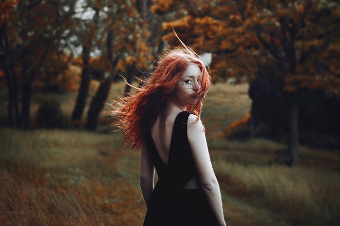 Redhead model with face paint in black dress