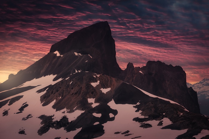 Mountain peaks with snow and dramatic sunset sky