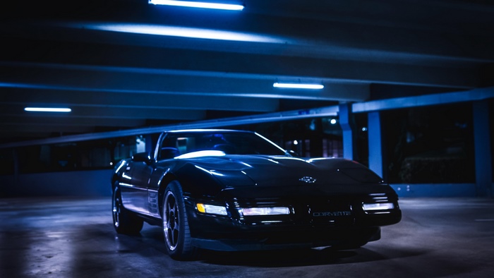Black Chevrolet Corvette C4 in parking garage