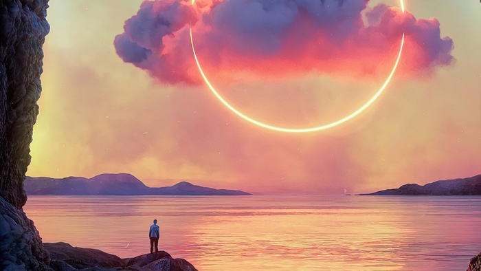Man standing on cliff overlooking ocean with glowing ring in sky