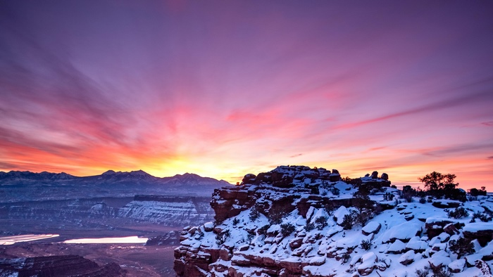 Desert landscape with snow and colorful sunset