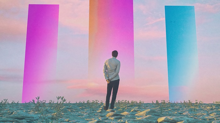 Man standing before three colorful portals in a desert landscape