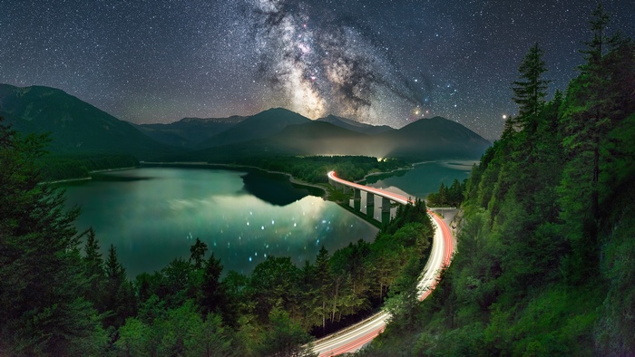 Milky Way over a lake and bridge with light trails