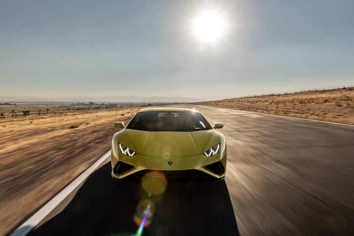 Yellow Lamborghini Huracan driving on a desert road