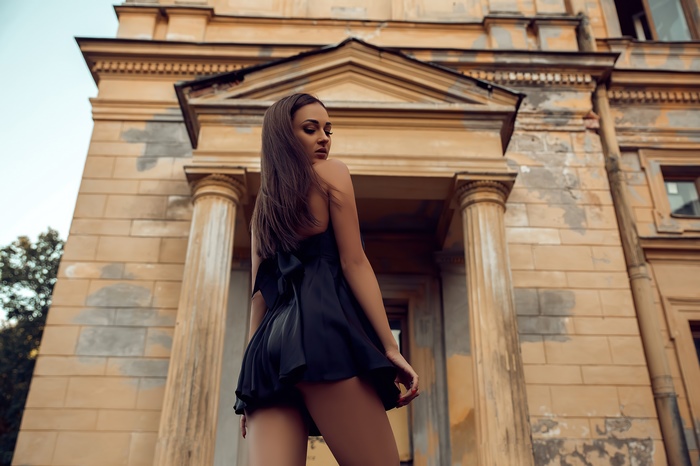 Model in black dress in front of old building