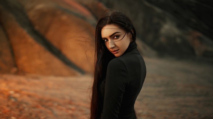 Woman in black dress in a rocky landscape