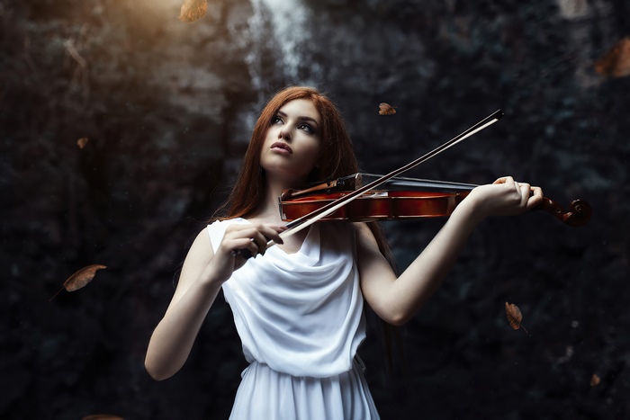 Girl playing violin with falling leaves