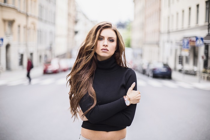 Brunette model in black turtleneck on city street