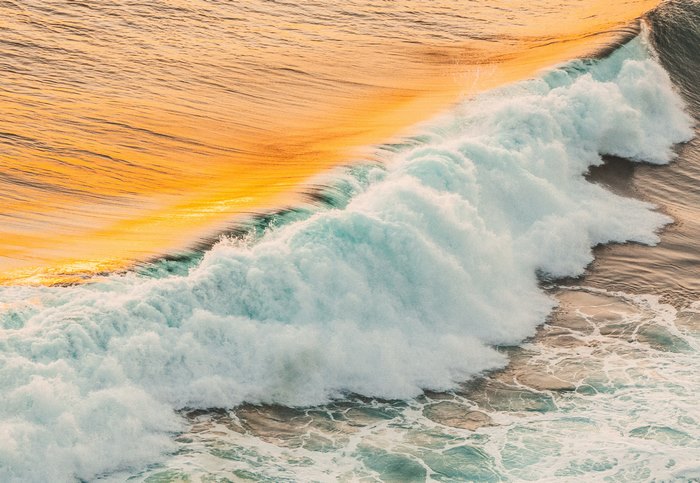 Ocean wave crashing at sunset, 4K
