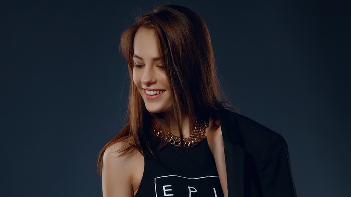 Model wearing black jacket and necklace