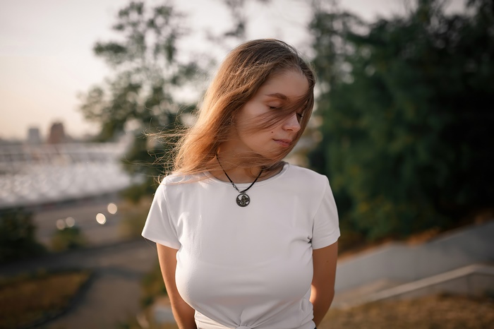 Girl with windblown hair wearing a white t-shirt