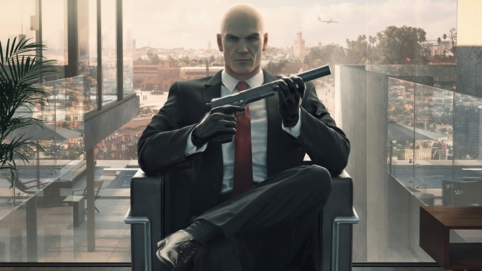 Agent 47 from Hitman holding a silenced pistol