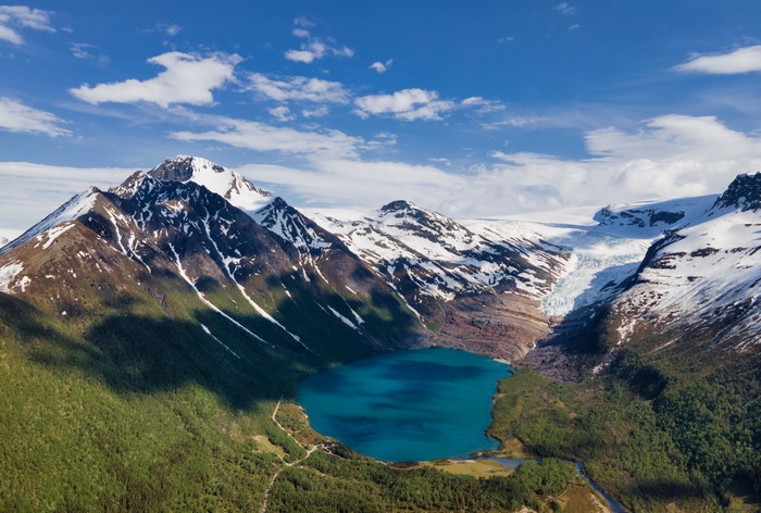 Turquoise lake surrounded by snow-capped mountains in Norway