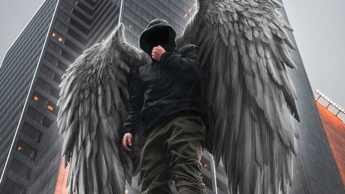 Hooded figure with angel wings in a city