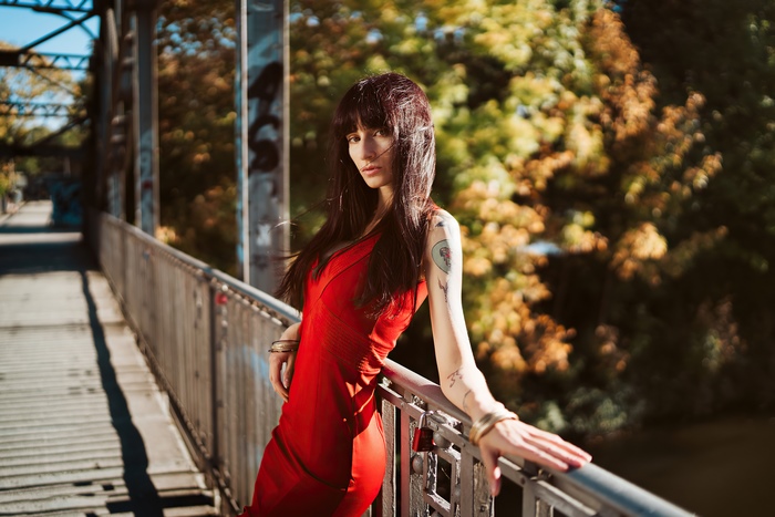 Woman with tattoos on a bridge