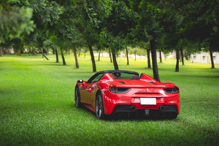 Red Ferrari 488 convertible on a grassy lawn