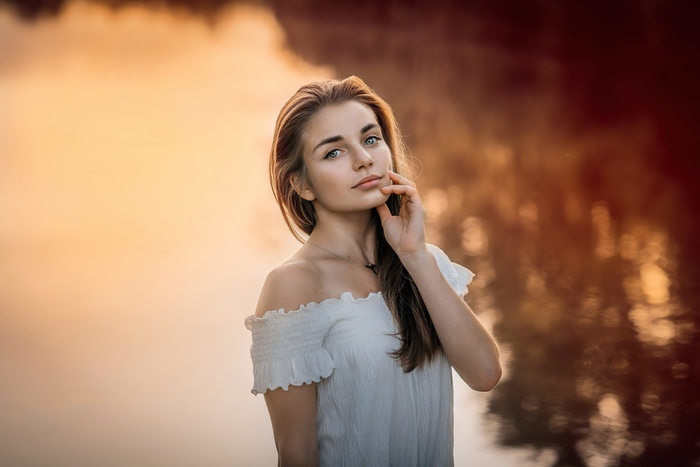 Young woman in white off-the-shoulder top by water