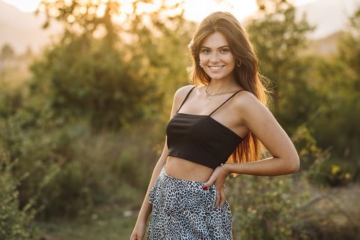 Young woman in crop top and leopard skirt smiling