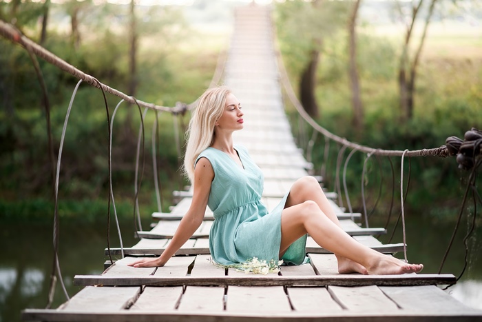 Woman Sitting on Suspension Bridge