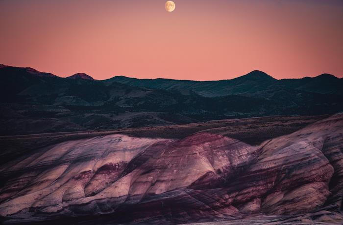 Moon over Painted Hills mountains at sunset 4K