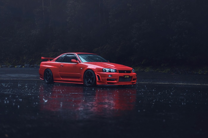 Red Nissan GT-R R34 on wet road