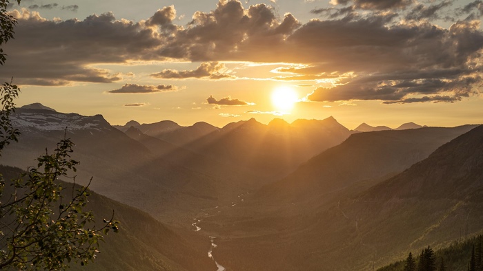 Sunset over mountains with clouds and valley