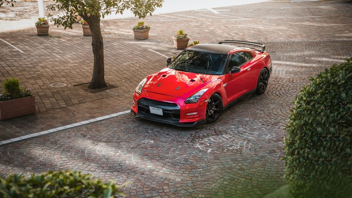 Red Nissan GT-R parked on cobblestone