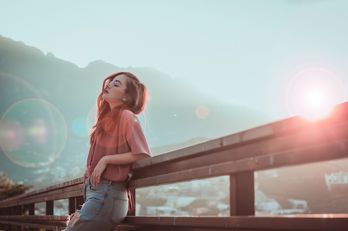 Girl wearing sunglasses leaning on a railing