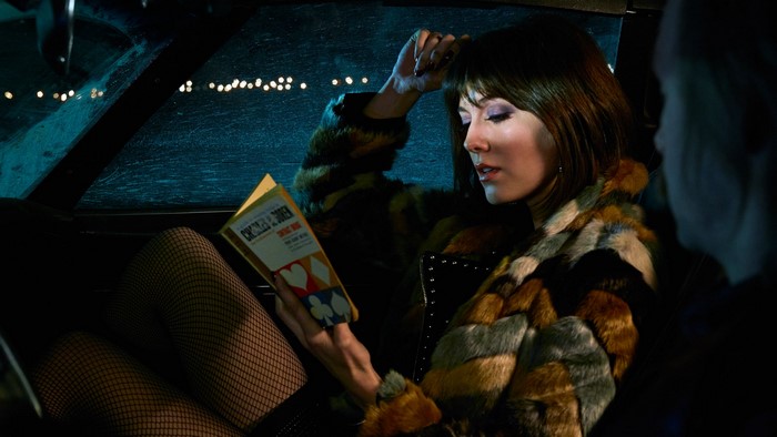 Woman reading a book in a car at night