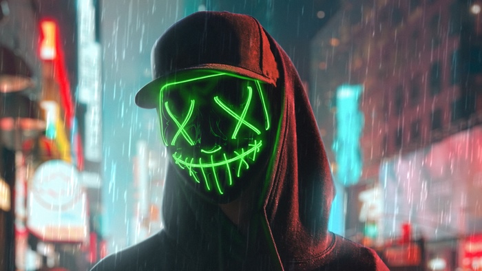 Person wearing a green neon mask and hoodie in the rain