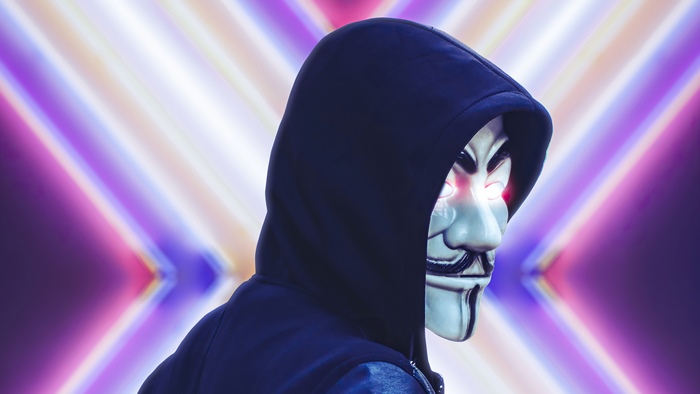 Anonymous mask wearer in front of neon lights