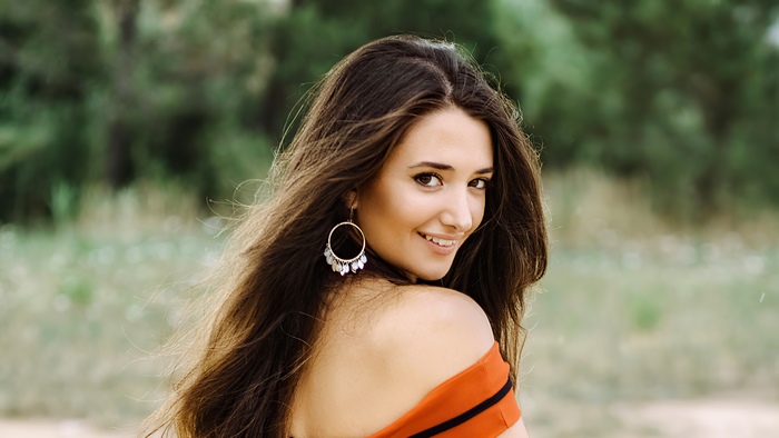 Woman with long brown hair and earrings