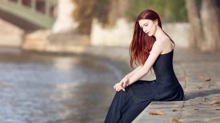 Woman in black dress by the water