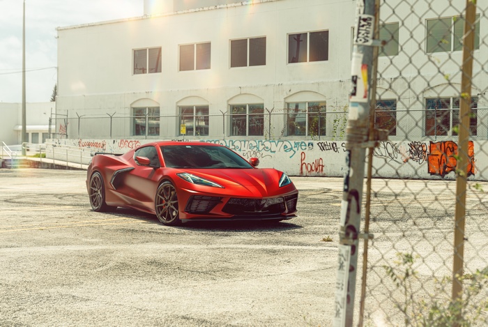Red Chevrolet Corvette Stingray C8 parked near graffiti wall