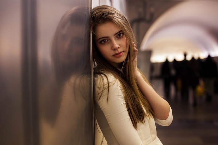 Young woman leaning against a wall
