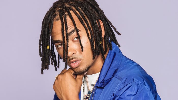 Ozuna with dreadlocks wearing a blue jacket