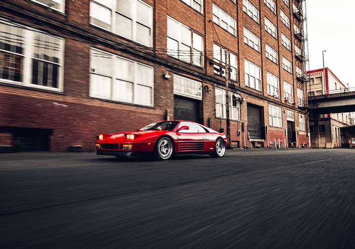 Red Ferrari 348 driving on a street