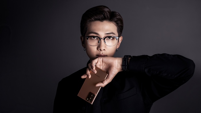 RM from BTS holding a Samsung phone