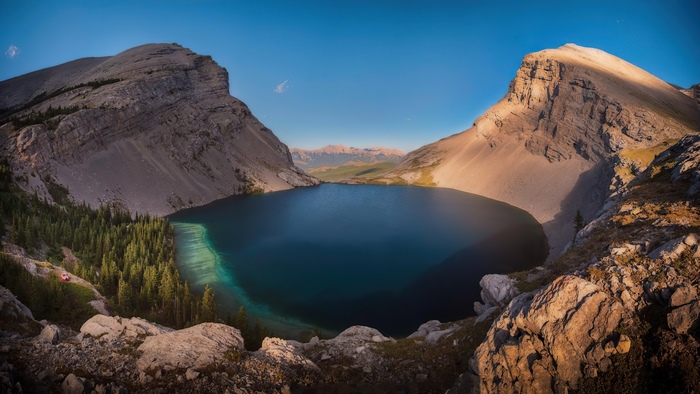 Mountain lake surrounded by rocky peaks and pine trees