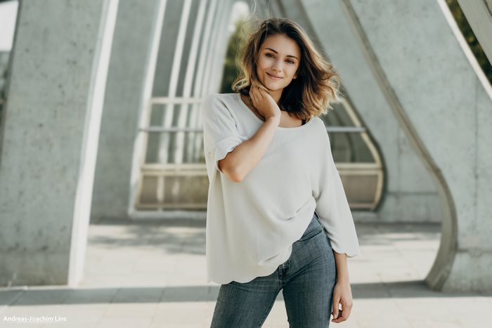 Girl smiling in white top and jeans