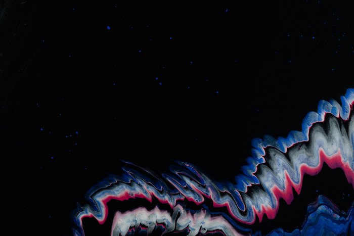 Abstract fluid art with blue and pink swirls on black