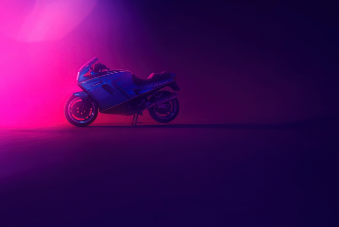 Blue Ducati 750 sport motorcycle with pink and purple lighting