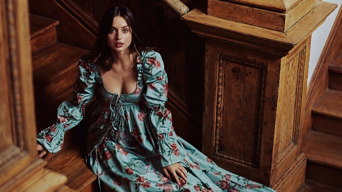 Ana de Armas sitting on wooden stairs